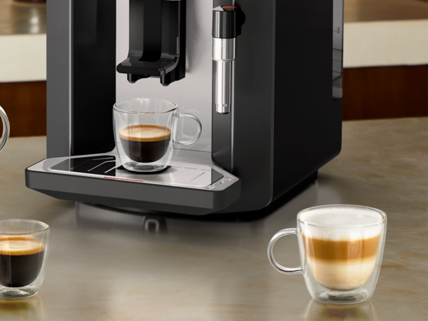 Machine à café sensation avec des tasses de café ainsi qu&apos;un gros plan sur le récolte goutte
